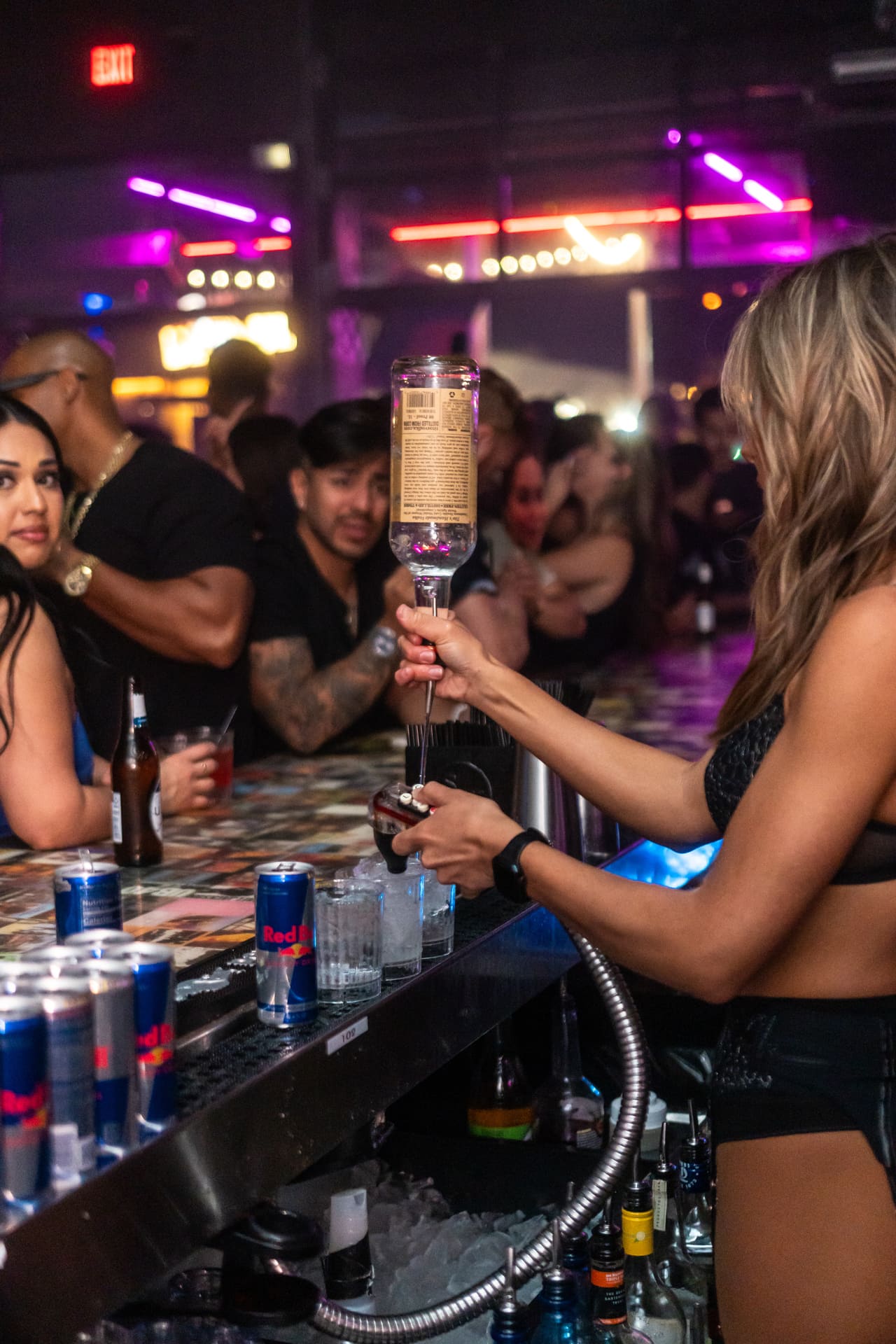 bartender serving from a bottle to people